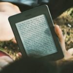 person holding black Amazon Kindle e-book reader